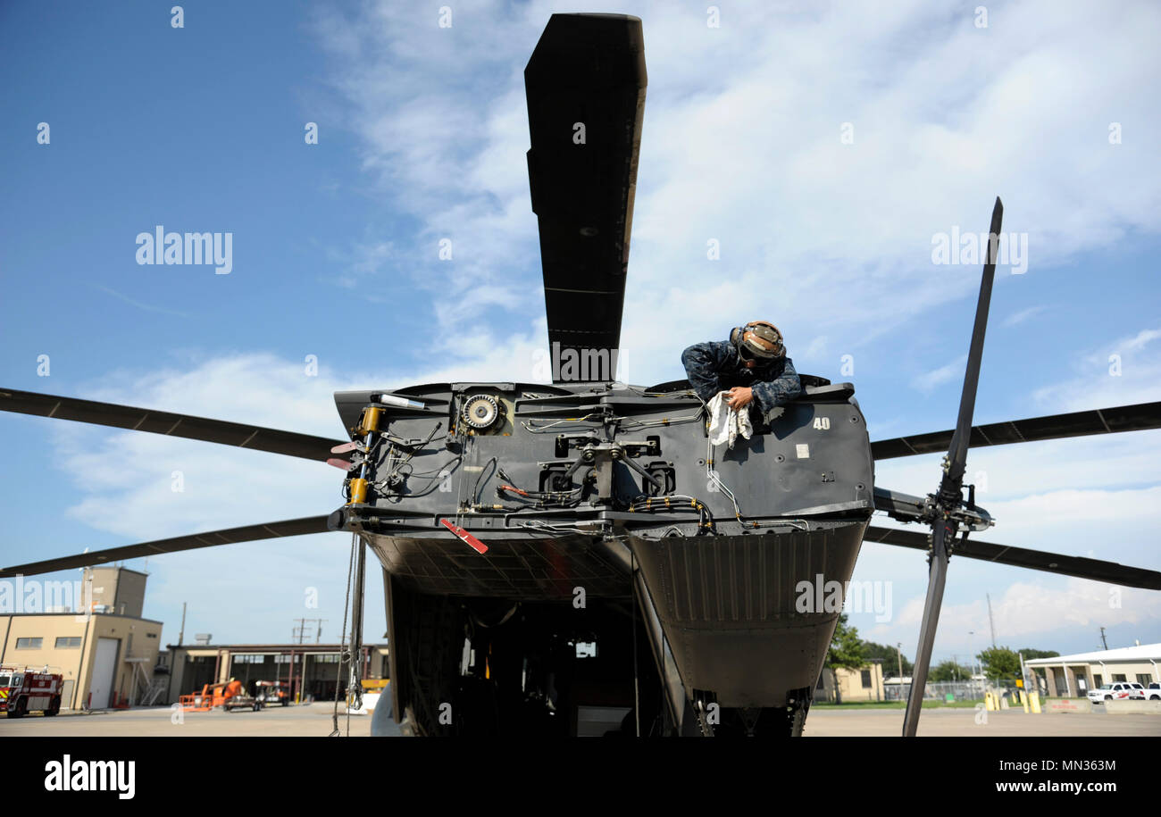 Stati Uniti Navy aviation electronics technician Priscilla Hernandez, assegnato per le avanguardie di elicottero di contromisure Mine Squadron (HM) 14, pulisce e ispeziona il Rotary di un MH-53 elicottero in preparazione per le operazioni di soccorso dopo l'uragano Harvey Agosto 28, 2017 a Naval Air Station giunto di base riserva di Fort Worth, Texas. Uragano Harvey fatto approdo nel sud-est della Texas, portando a registrare le inondazioni e distruzione per la regione. I militari Usa attività supportate FEMA nonché delle autorità statali e locali di salvataggio e di soccorso. (U.S. Air Force photo by Staff Sgt. Ian Hoachlander) Foto Stock