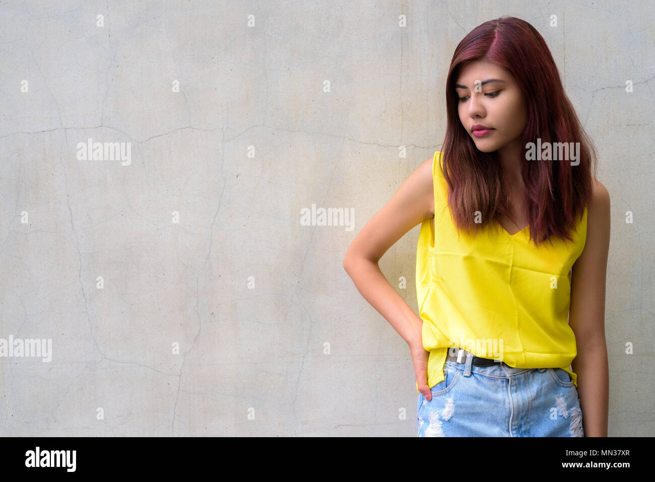 Bella ragazza adolescente indossando vibrante maglietta gialla Foto Stock