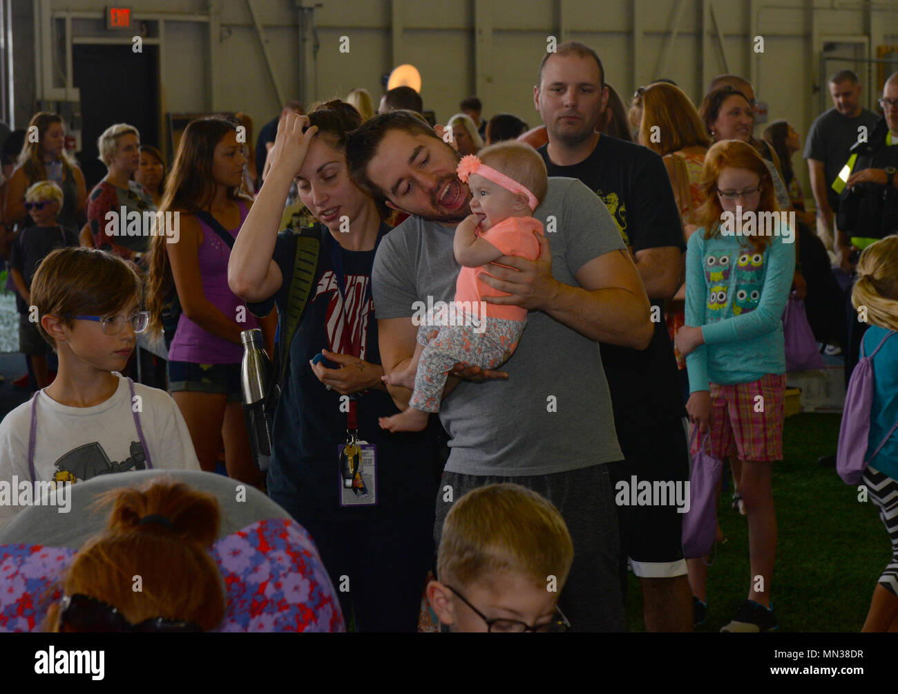 Le famiglie che frequentano l'annuale Ritorno a scuola Round Up caso attendere in linea per ricevere gratuitamente la scuola nell'orgoglio Hangar su Ellsworth Air Force Base, S.D., Agosto 26, 2017. Avieri e famiglie hanno avuto la possibilità di ricevere le forniture come zaini, matite e quaderni prima il il 2017-2018 Anno scolastico è iniziato. (U.S. Air Force foto di Airman Nicolas Z. Erwin) Foto Stock