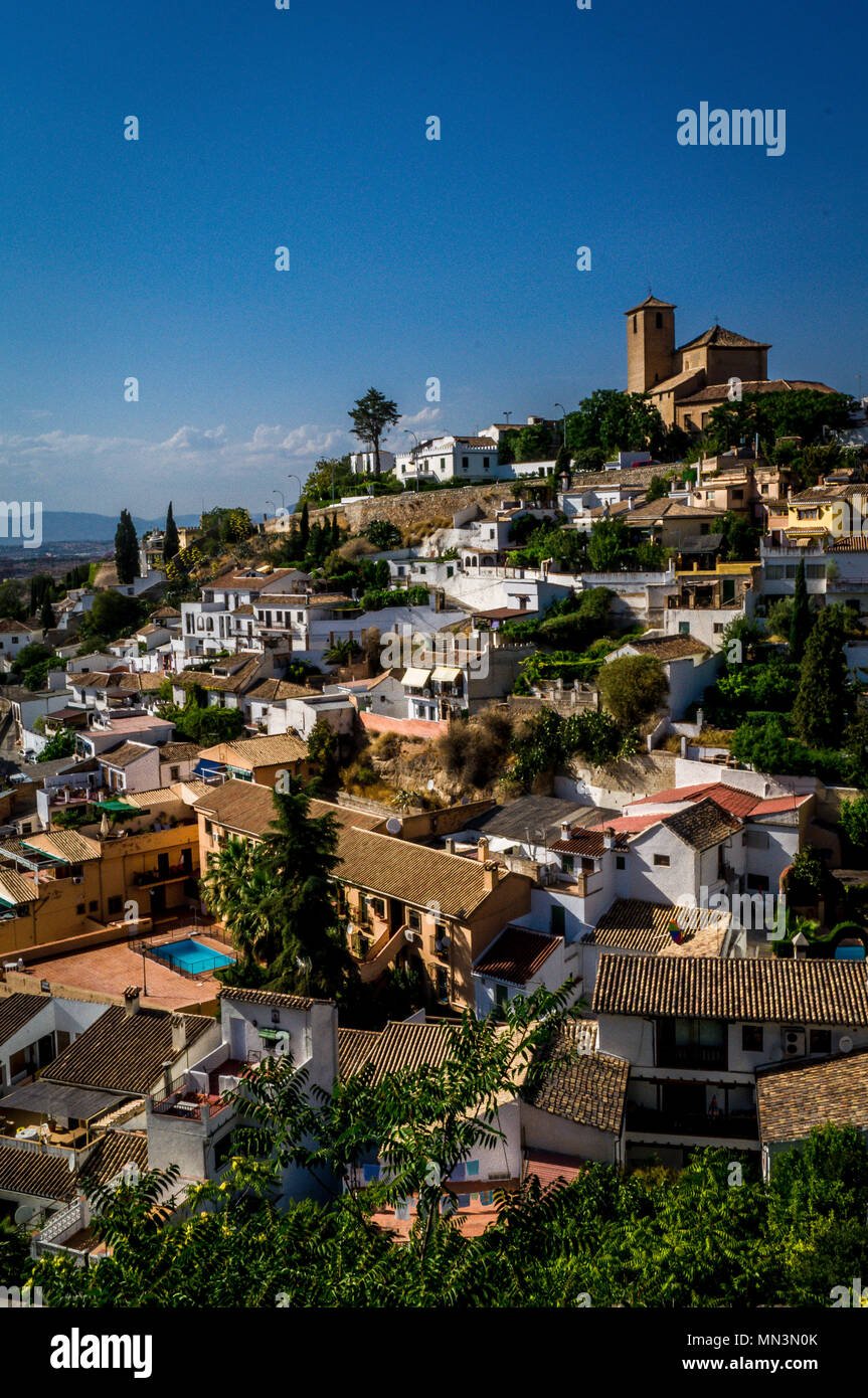 Granada chiesa sulla cima di una collina visto dall'Alhambra su un luminoso giorno di sole Foto Stock