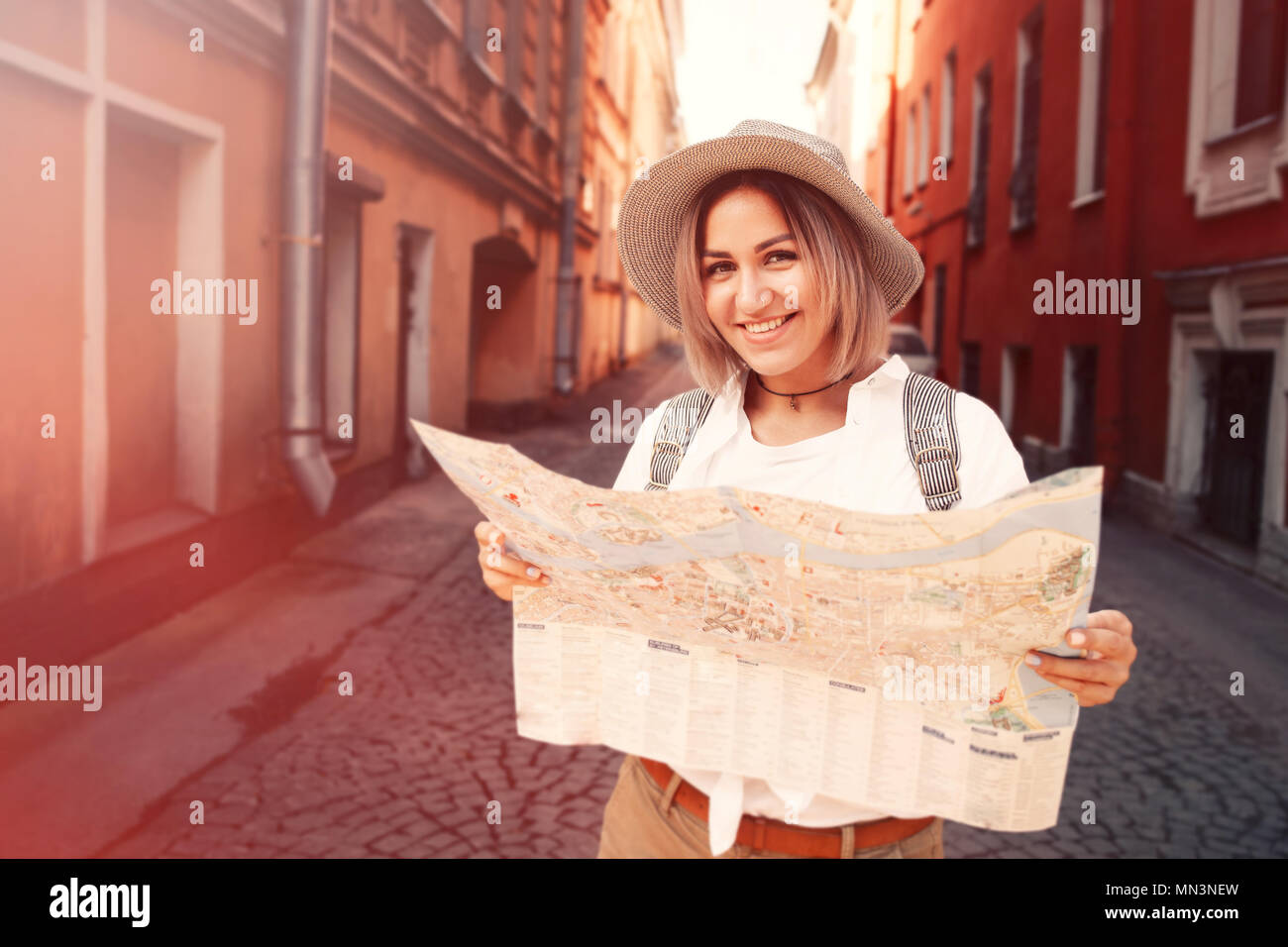 Guida di viaggio. Giovani viaggiatori femmina con zaino e con la mappa sulla strada. Concetto di viaggio. Avventura Foto Stock