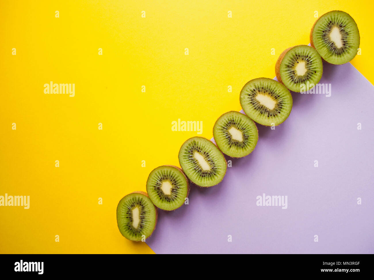 Kiwi in giallo e viola chiaro dello sfondo. Foto Stock