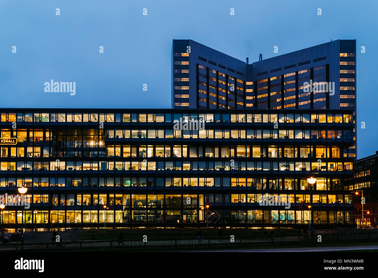 AMSTERDAM, PAESI BASSI - Novembre 08, 2017: Occupato edifici per uffici durante la notte nella città di Amsterdam Foto Stock