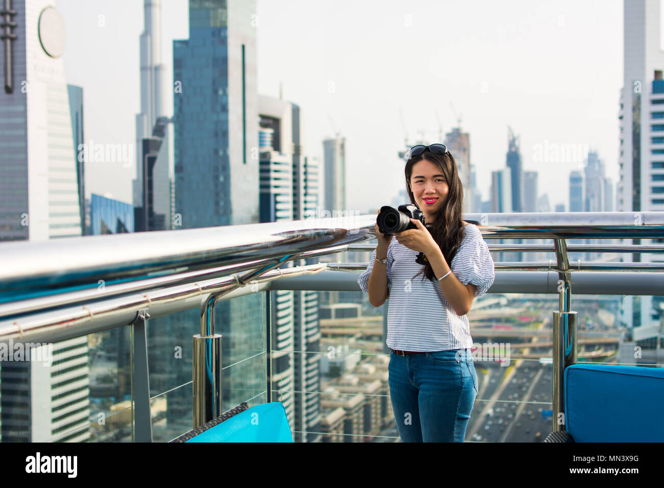 Fotografo femmina di scattare una foto del paesaggio urbano di Dubai Foto Stock