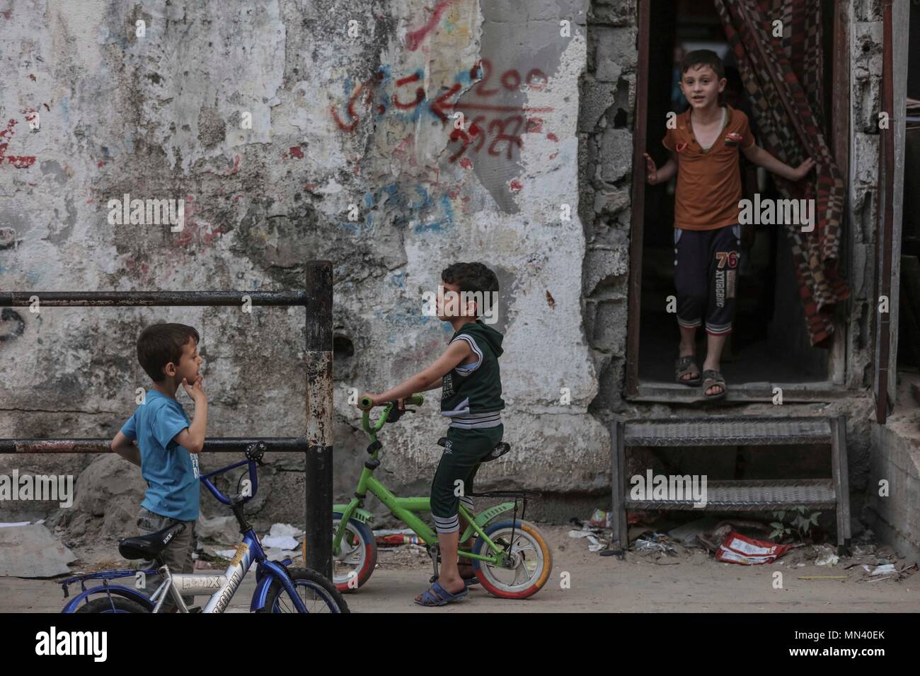 (180514) -- GAZA, 14 maggio 2018 (Xinhua) -- dei bambini rifugiati Palestinesi giocare al di fuori della loro casa di Jabalia Refugee Camp, nel nord della Striscia di Gaza, il 13 maggio 2018. La giornata la Nakba, o 'Day di catastrofe", il 15 maggio è contrassegnato dai palestinesi in memoria del trasferimento forzato di due terzi della popolazione palestinese e la pulizia etnica di almeno 418 villaggi come risultato della guerra 1948. (Xinhua/Wissam Nassar) (zxj) Foto Stock
