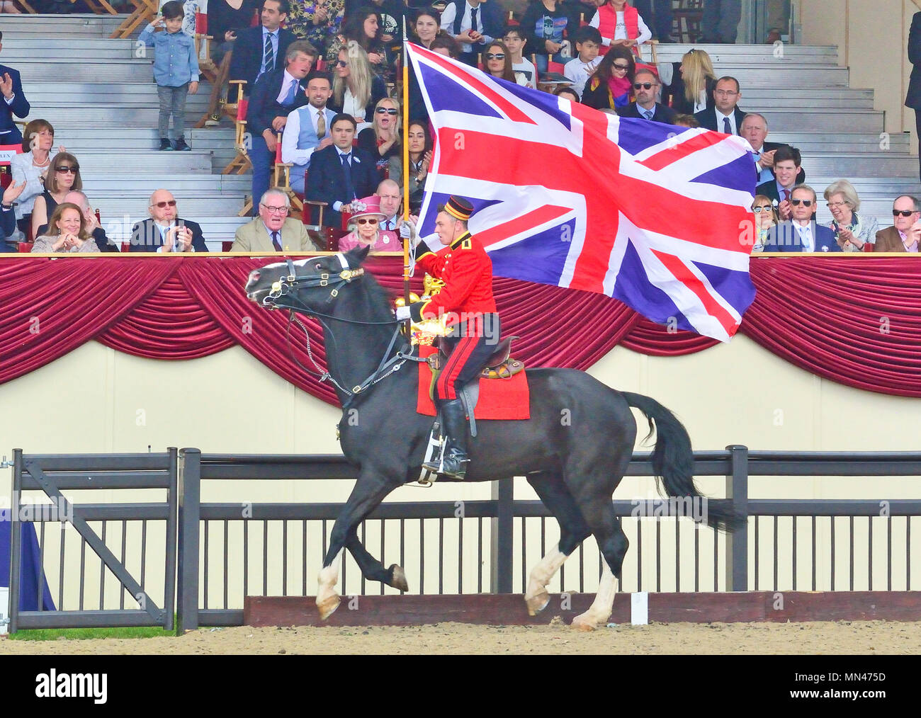 Castello di Windsor, Regno Unito. 13 maggio 2018. Castello di Windsor, Regno Unito. 13 maggio 2018. The Royal Windsor Horse Show at Home Park Private Windsor Castle Union Jack bearer bandiera corre intorno alla Castle Arena di fronte alla Regina in rosa, come finale dopo il Musical Drive of the King's Troop Royal Horse Artillery Credit: Gary Blake /Alamy Live News Foto Stock