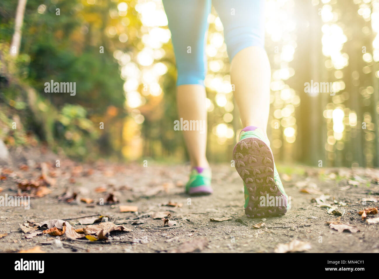 Donna passeggiate ed escursioni nella foresta di autunno, scarpe sportive. Jogging, trekking o di formazione al di fuori in autunno la natura. Ispirando la salute e il fitness concetto. Foto Stock