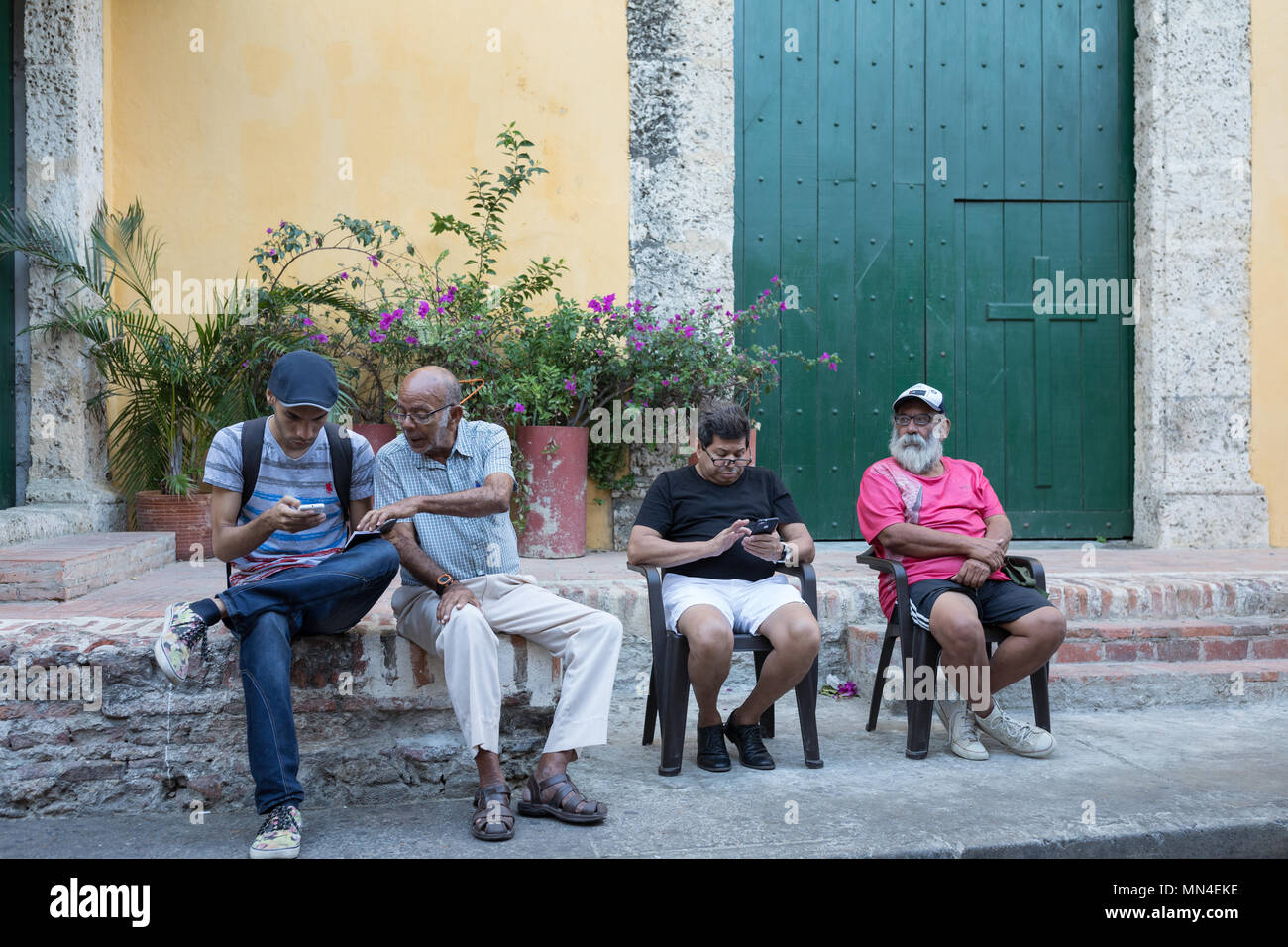 Gli uomini controllare i loro telefoni cellulari , Getsemani, Cartagena, Colombia, Sud America Foto Stock