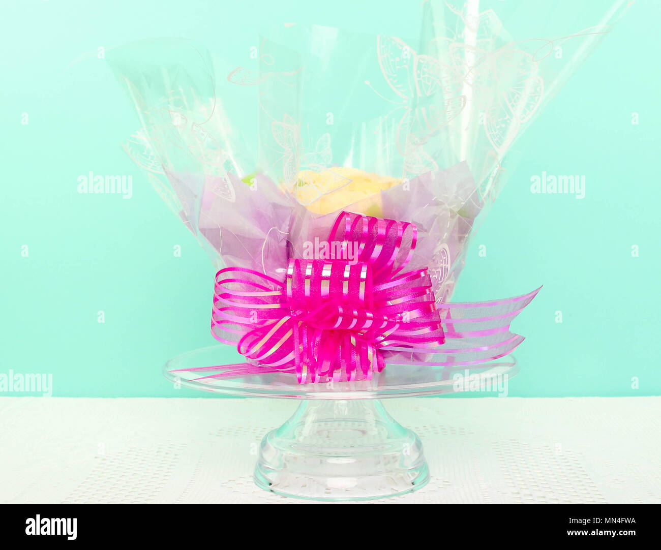 Compleanno, Celebrazione torta con nastro rosa su sfondo blu con tavolo bianco. Foto Stock
