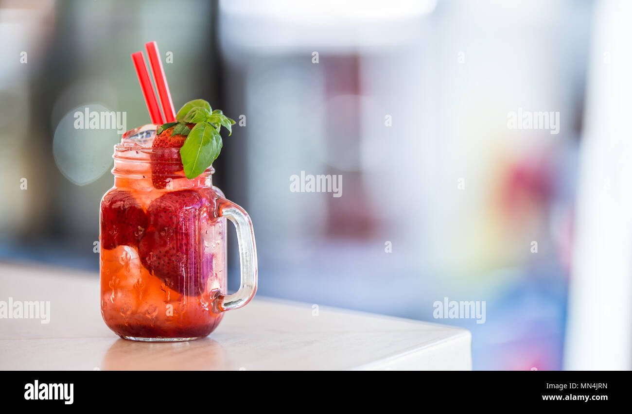 Fragola non limonata alcolica con basilico e cubetti di ghiaccio. Foto Stock