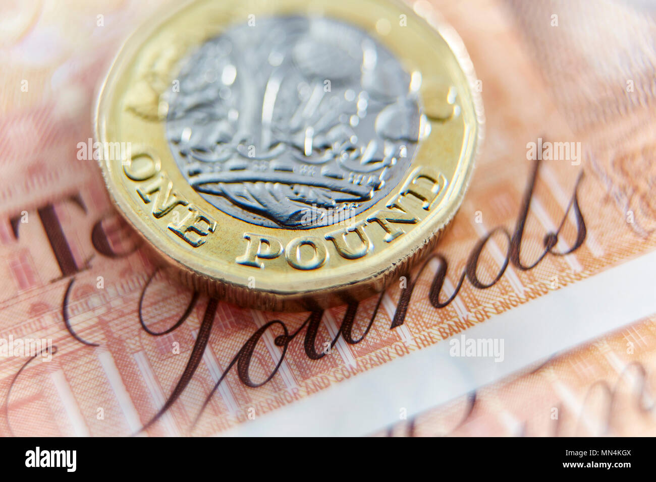 Chiudere fino a una libbra moneta su dieci pound nota Foto Stock