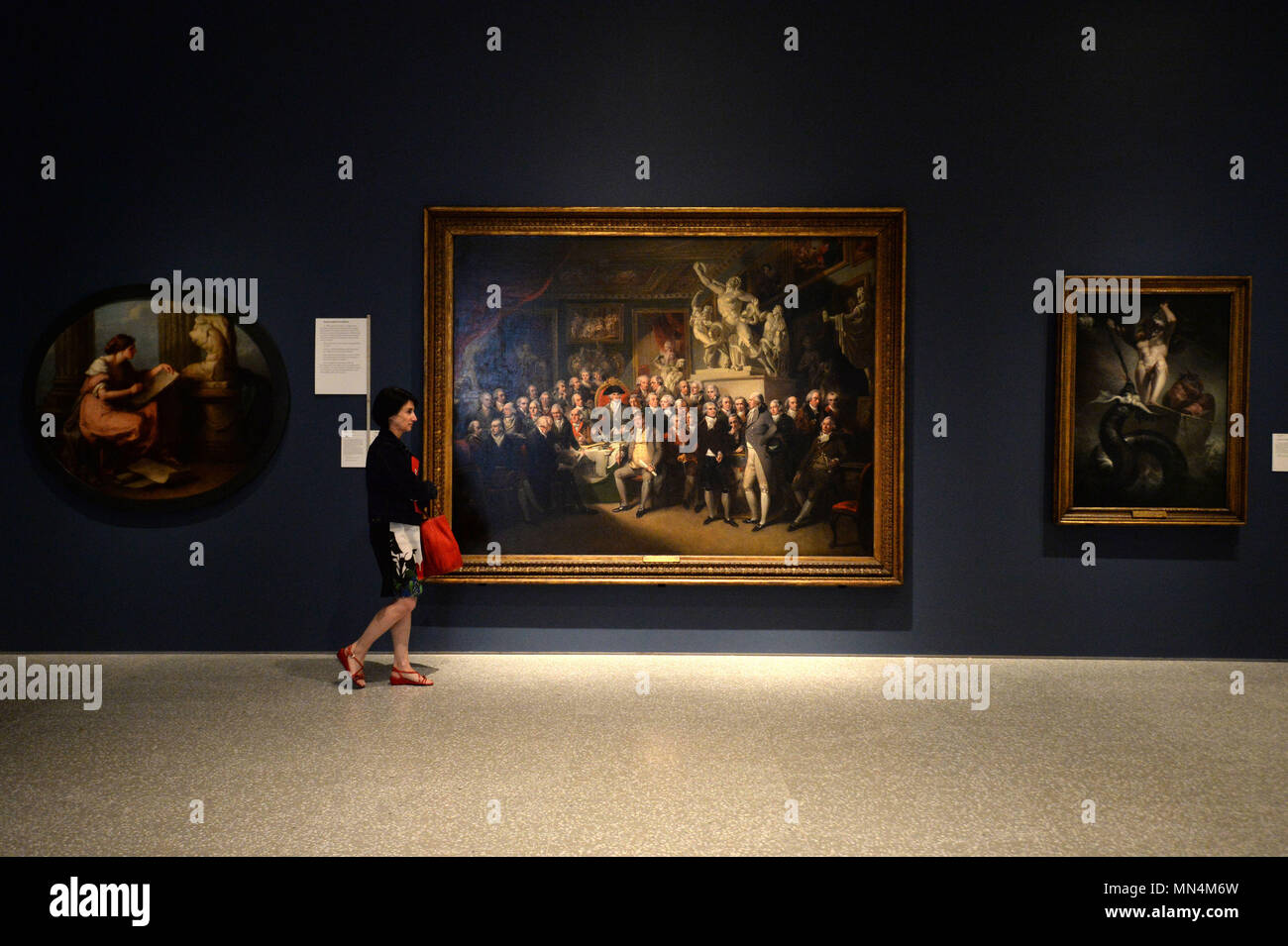 Un visitatore guarda 'gli accademici reali riuniti nella loro Camera di Consiglio per giudicare le Medaglie agli studenti di successo in Pittura, scultura, architettura e disegno' di Henry Singleton (centro), Al lancio della nuova Royal Academy of Arts di Londra, a seguito di una trasformazione di Sir David Chipperfield RA e sostenuta dalla National Lottery. Foto Stock