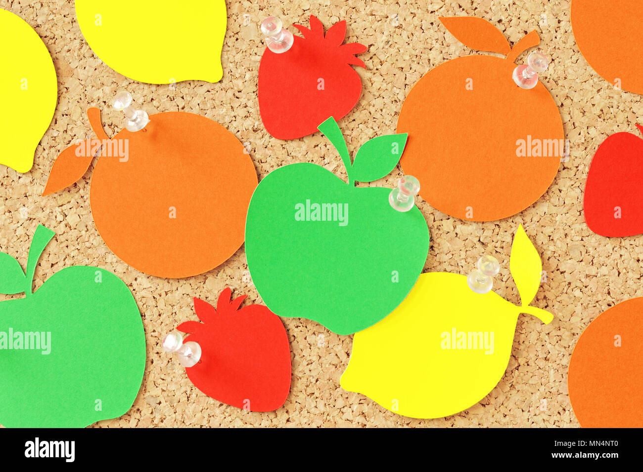 Frutta di carta a forma di nota sulla lavagna di sughero Foto Stock