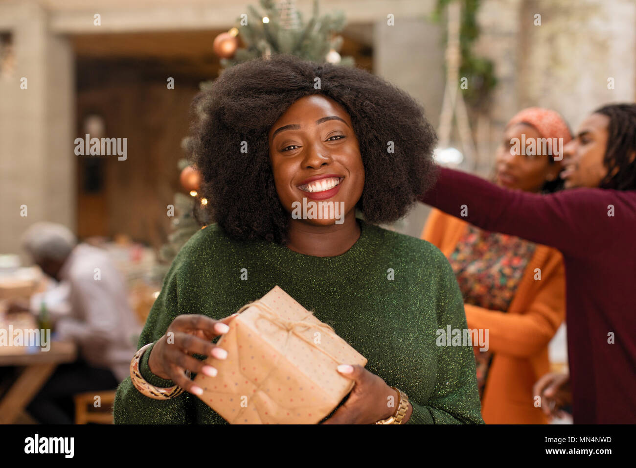 Ritratto sorridente, fiducioso giovane donna azienda regalo di Natale Foto Stock