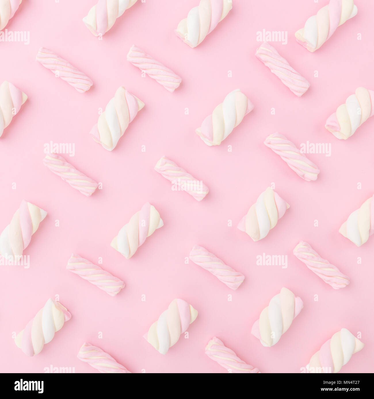 Diversi colori pastello marshmallows in rosa pastello con sfondo spazio copia. Vista dall'alto. Concettuale Trend alimentari laici piatta Foto Stock
