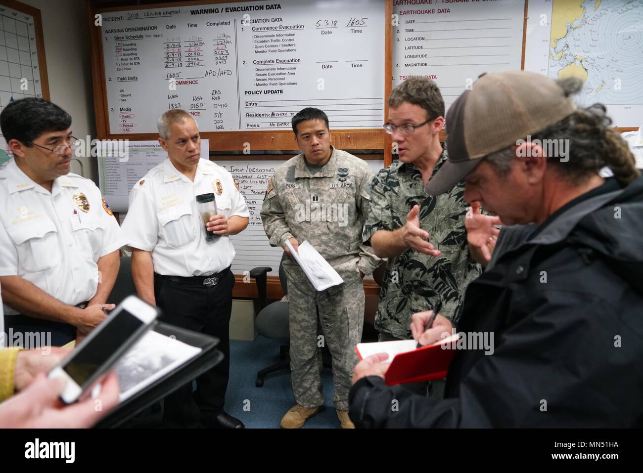 Esercito Capt. Jayson Yang, Task Force Hawaii Aviation Liaison Officer, frequenta la sincronizzazione di aviazione breve con i rappresentanti di aviazione da Hawaii County Fire Department e University of Hawaii aeromobili senza equipaggio Dipartimento durante la mattinata breve a Hawaii contea di Difesa Civile, Maggio 09, 2018. L'Hawaii National Guard dispone di essere attivato per assistere Hawaii County agenzie governative in risposta al focolaio di origine vulcanica sull isola delle Hawaii il funzionamento viene indicato come Task Force Hawaii. (U.S. Air National Guard Foto di Tech. Sgt. Andrew Jackson) Foto Stock