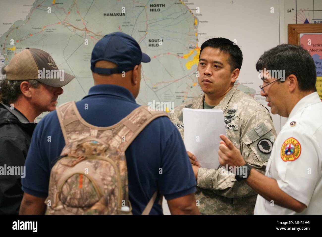 Esercito Capt. Jayson Yang, Task Force Hawaii Aviation Liaison Officer, frequenta la sincronizzazione di aviazione breve con i rappresentanti di aviazione da Hawaii County Fire Department e University of Hawaii aeromobili senza equipaggio Dipartimento durante la mattinata breve a Hawaii contea di Difesa Civile, Maggio 09, 2018. L'Hawaii National Guard dispone di essere attivato per assistere Hawaii County agenzie governative in risposta al focolaio di origine vulcanica sull isola delle Hawaii il funzionamento viene indicato come Task Force Hawaii. (U.S. Air National Guard Foto di Tech. Sgt. Andrew Jackson) Foto Stock