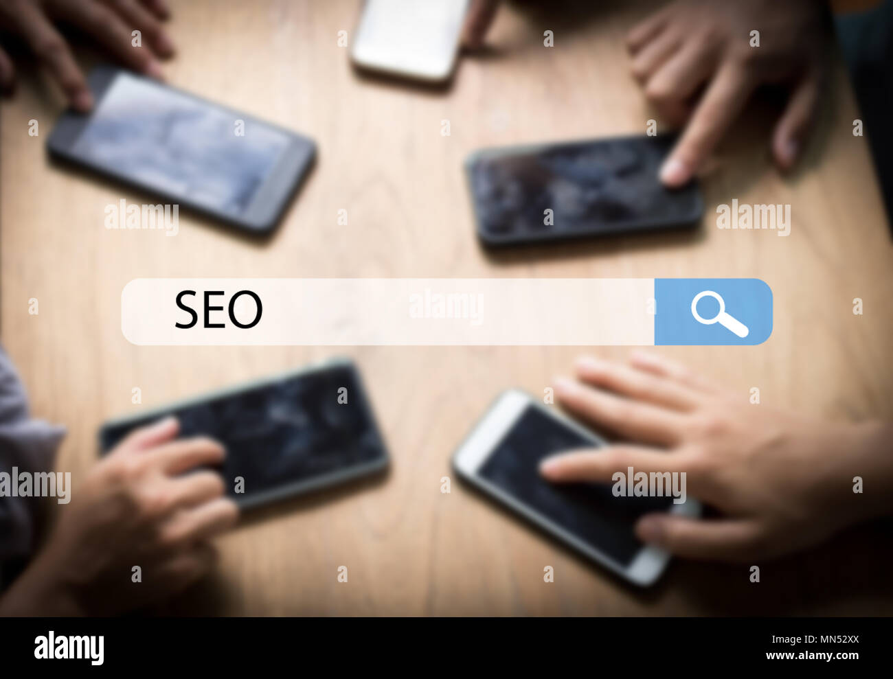 Il motore di ricerca Ottimizzazione SEO il concetto di esplorazione, team di imprenditore di pressatura e utilizzando il telefono per cercare informazioni sulla tavola Foto Stock