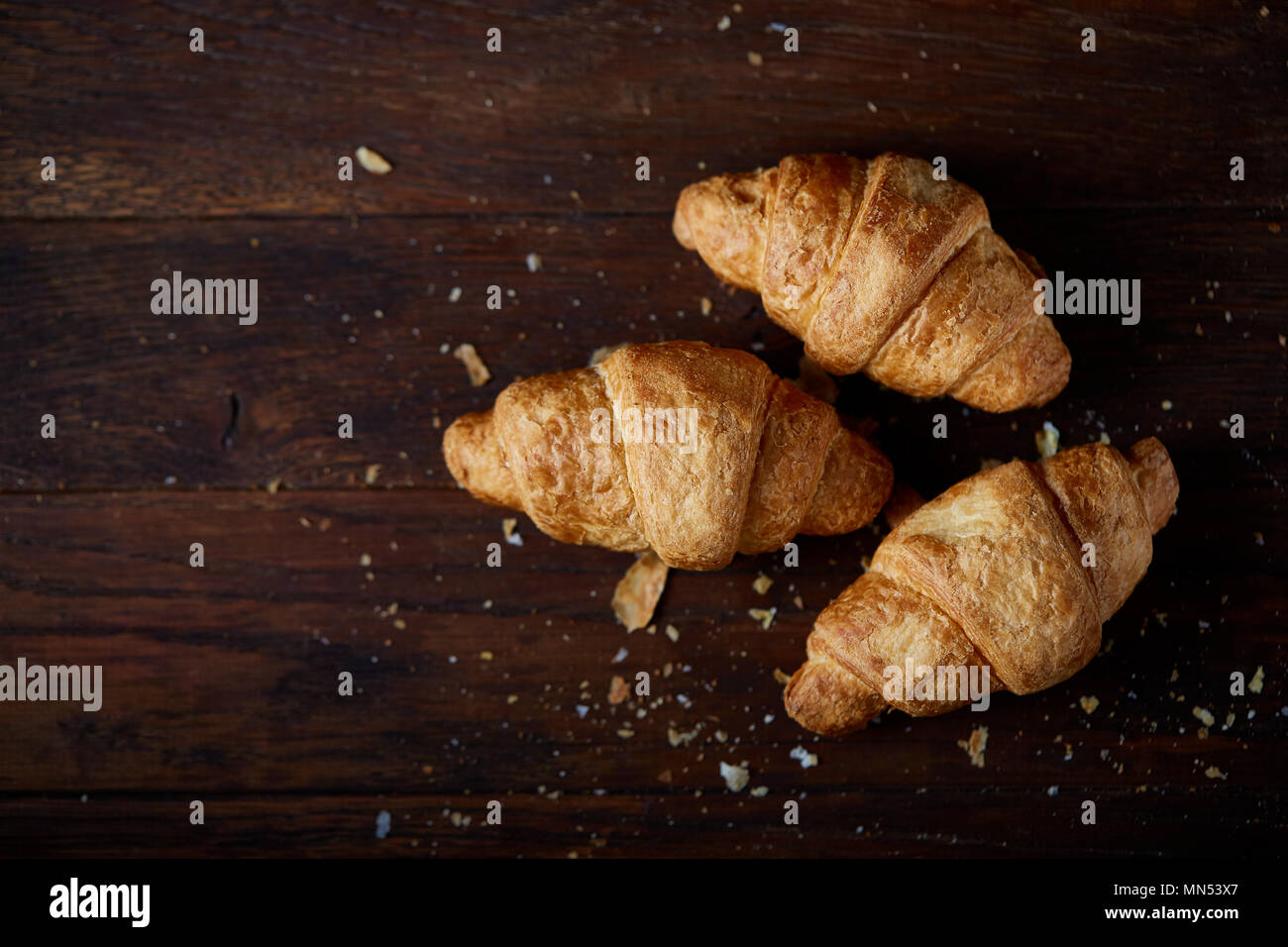 Gustosi croissant burroso su un vecchio tavolo di legno, close-up, il fuoco selettivo, la profondità di campo. Deliziosi dolci. Tradizionale breakfas continentale Foto Stock