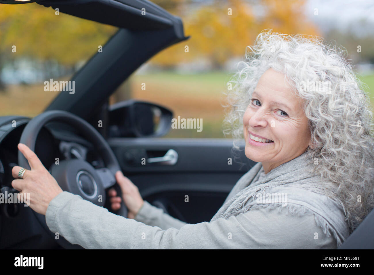 Ritratto sorridente donna senior convertibile di guida Foto Stock