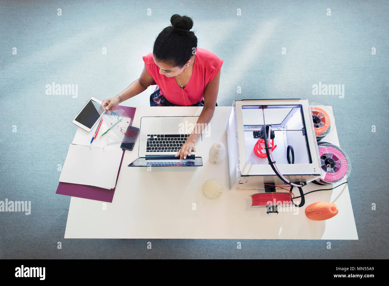 Designer femmina al computer portatile accanto alla stampante 3D Foto Stock