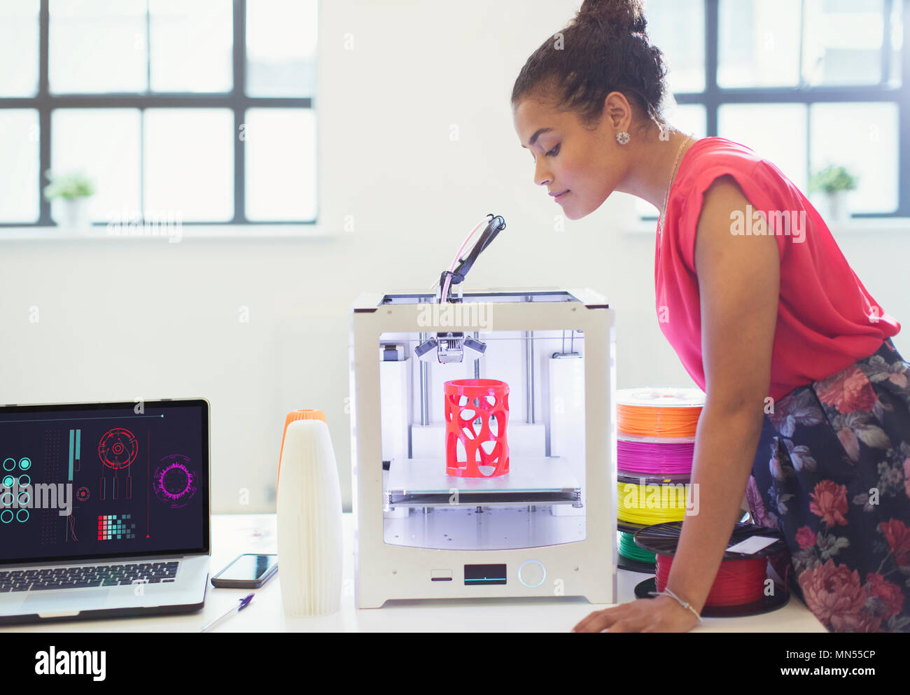 Designer femmina guarda la stampante 3D Foto Stock