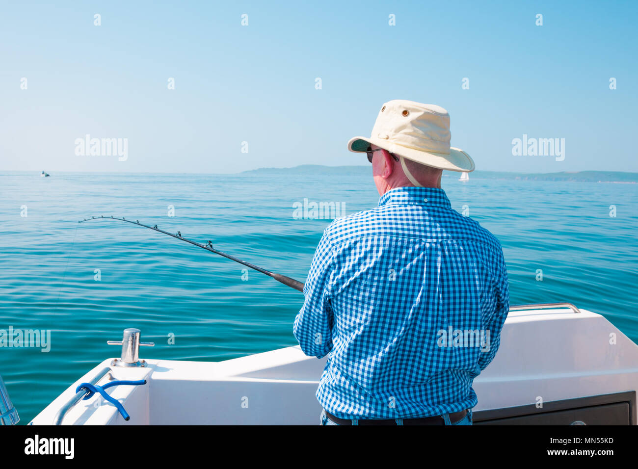 Un uomo la pesca al di fuori di una piccola imbarcazione, REGNO UNITO Foto Stock