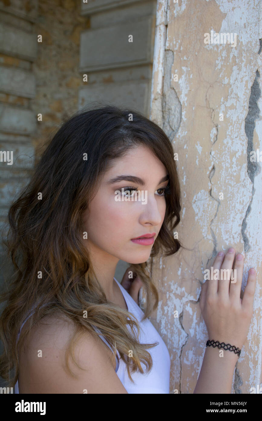 Beautidful teen girl mano toccando la parete che guarda lontano Foto Stock