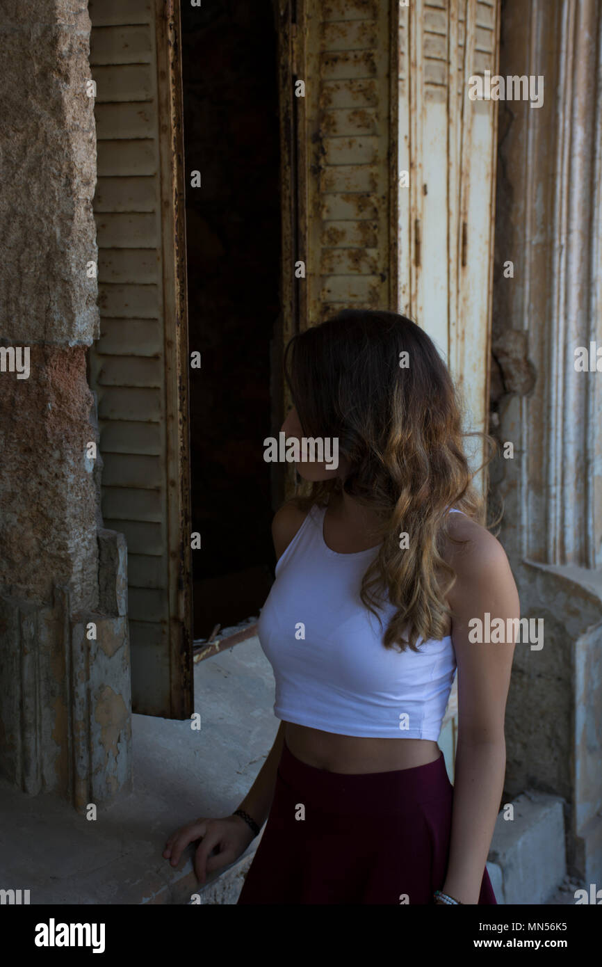 Teen girl in piedi al di fuori di un edificio abbandonato Foto Stock