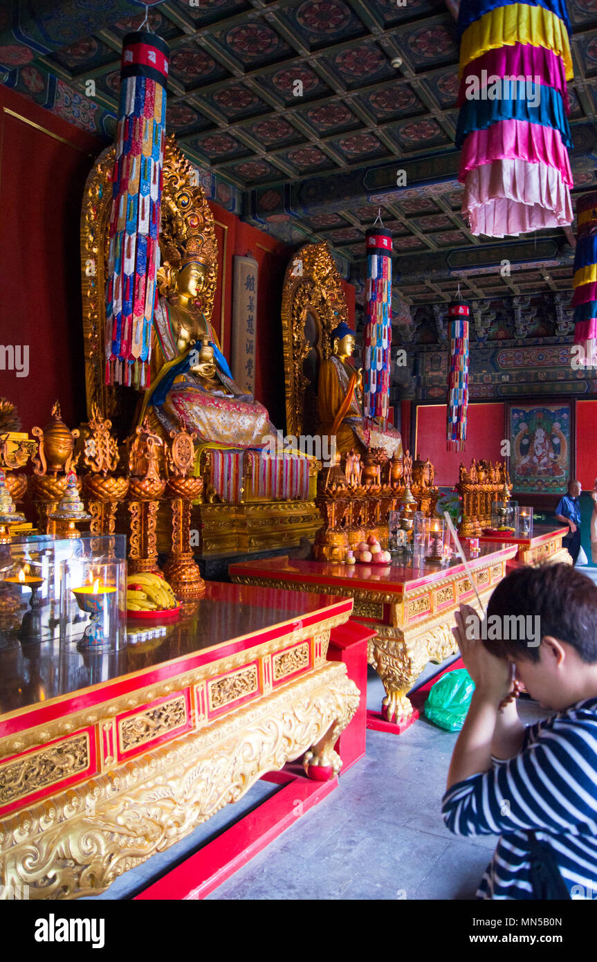 Il interni colorati di un tempio presso il centro storico di Tempio di Yonghegong a Pechino in Cina, con divinità seduto e altri iconografia religiosa. Foto Stock
