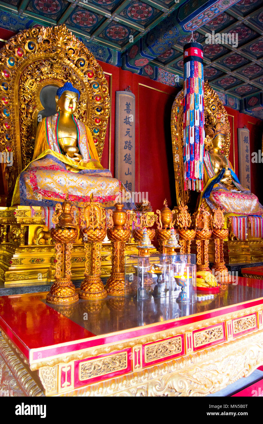 Il interni colorati di un tempio presso il centro storico di Tempio di Yonghegong a Pechino in Cina, con divinità seduto e altri iconografia religiosa. Foto Stock