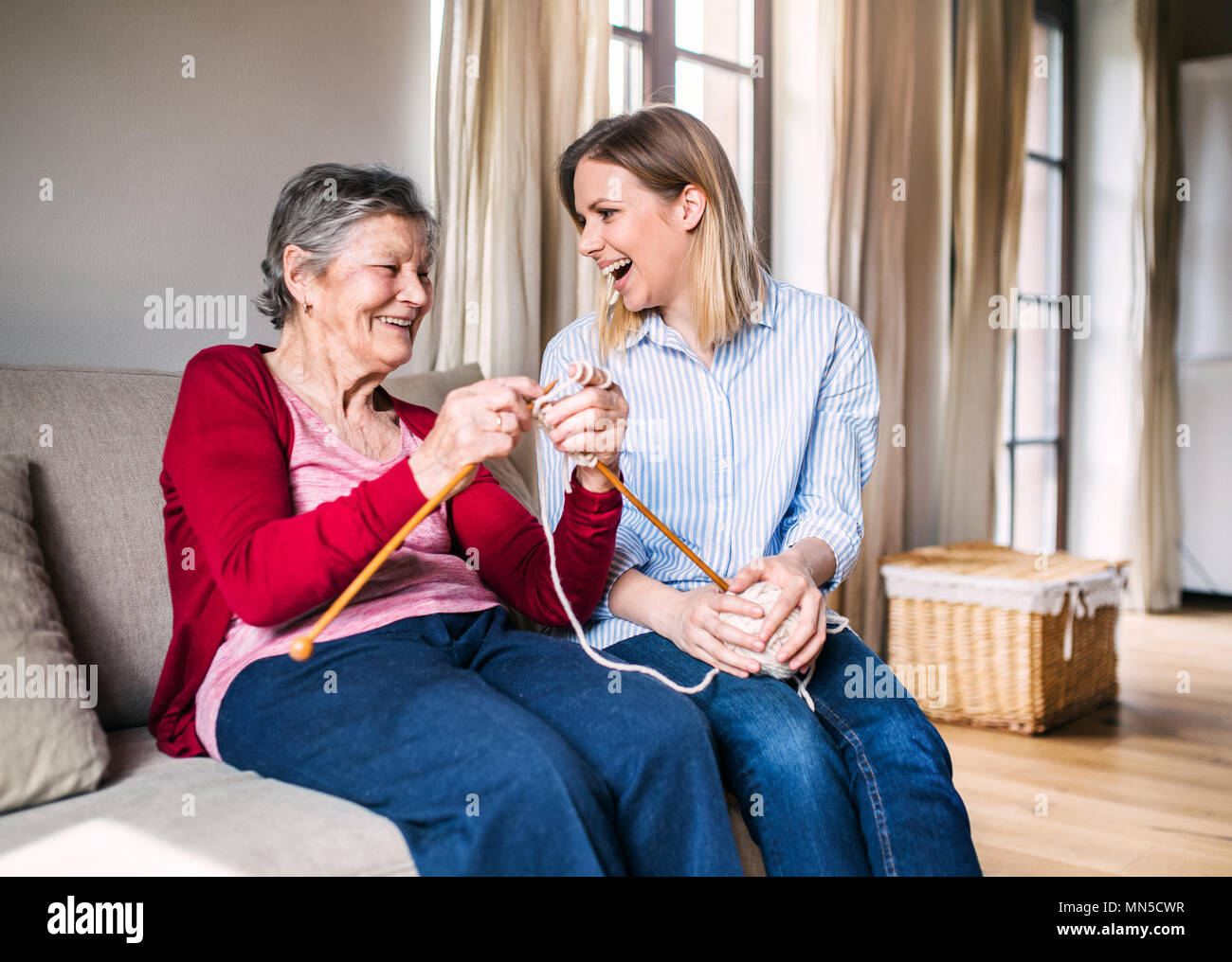 Una Nonna e nipote di adulto a casa avendo divertimento maglia. Foto Stock
