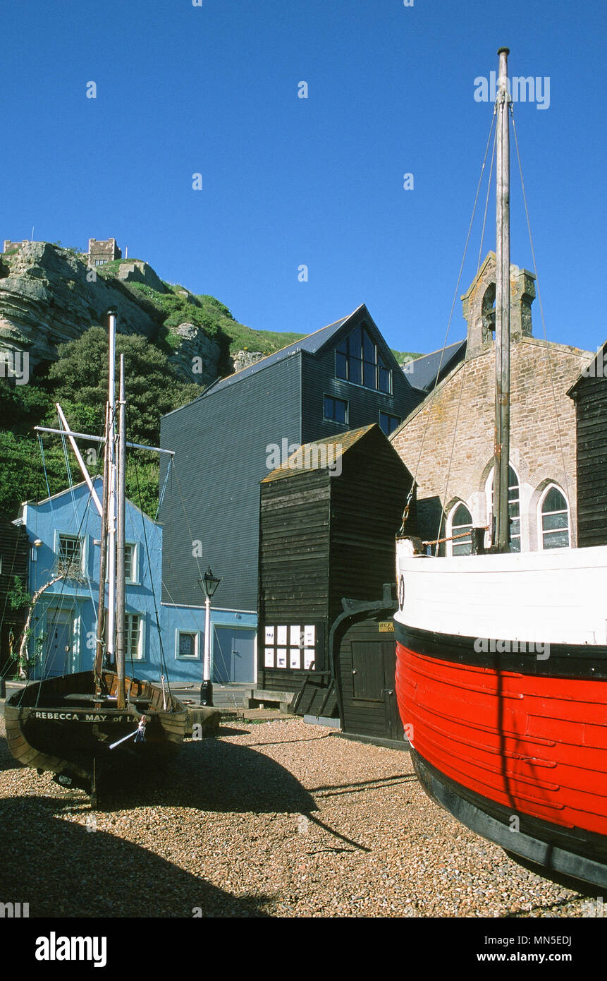 La Stade a Hastings, East Sussex, sulla costa sud, con barche e net capannoni e East Hill nel backgroundd Foto Stock