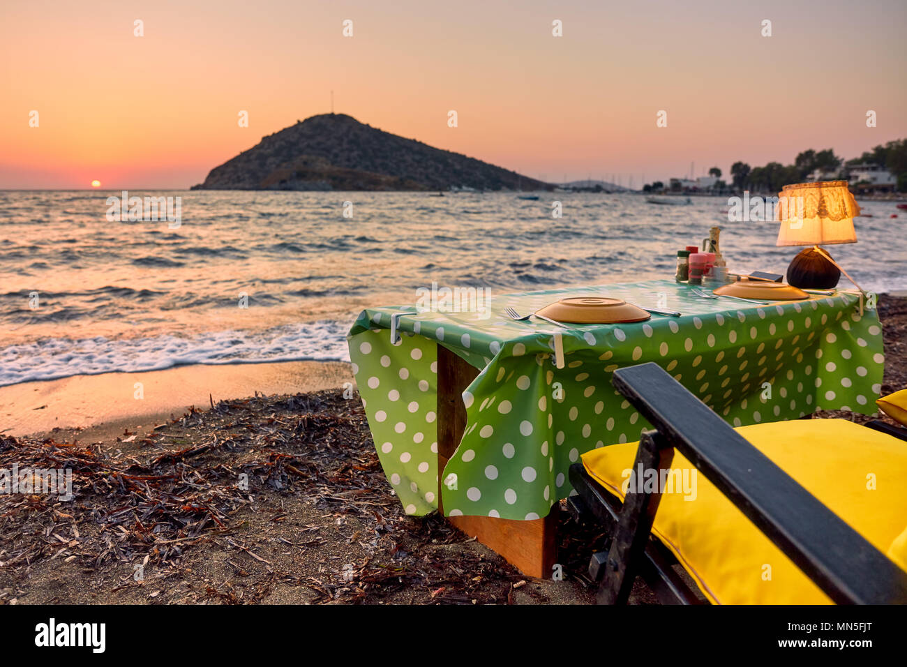 Cena romantica impostazione sulla spiaggia al tramonto a Bodrum, Gumusluk, Turchia. Foto Stock
