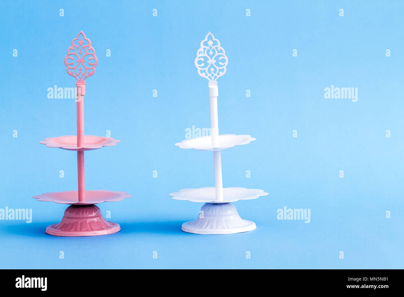 Rosa tier i vassoi su sfondo blu Foto Stock
