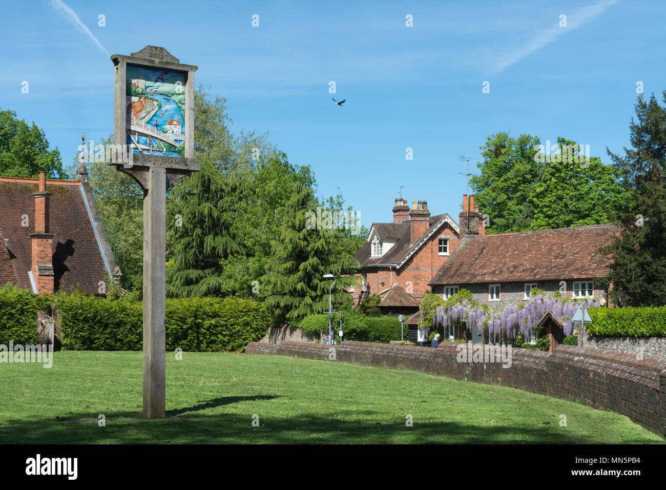 Legno decorativo segno del villaggio e coperto di glicine cottages in Goring-on-Thames in Oxfordshire, Regno Unito Foto Stock