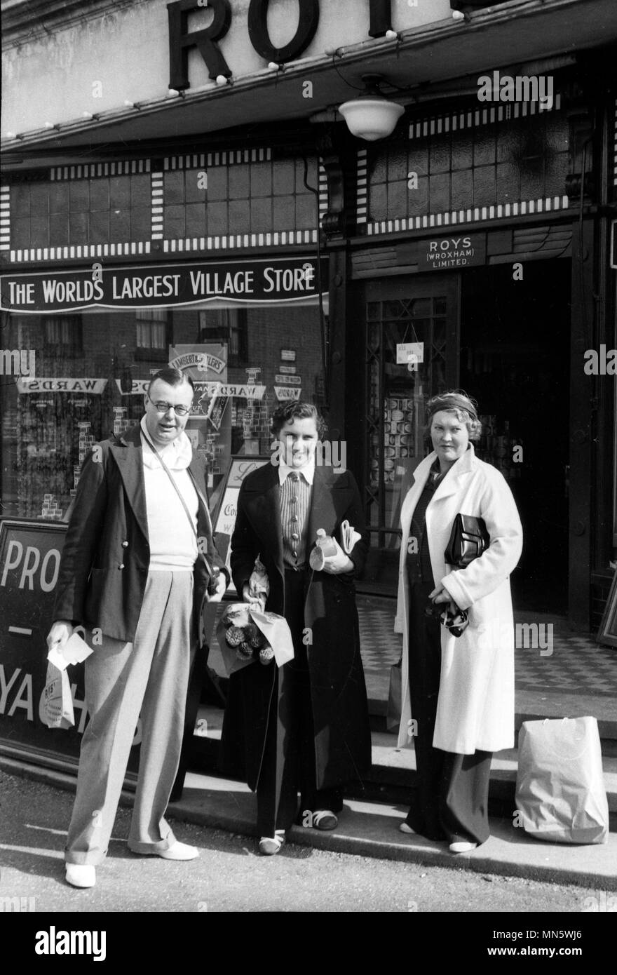I clienti turistici al di fuori Roys shop " Il più grande villaggio Store in tutto il mondo " a Wroxham Regno Unito Norfolk 1940s Foto Stock