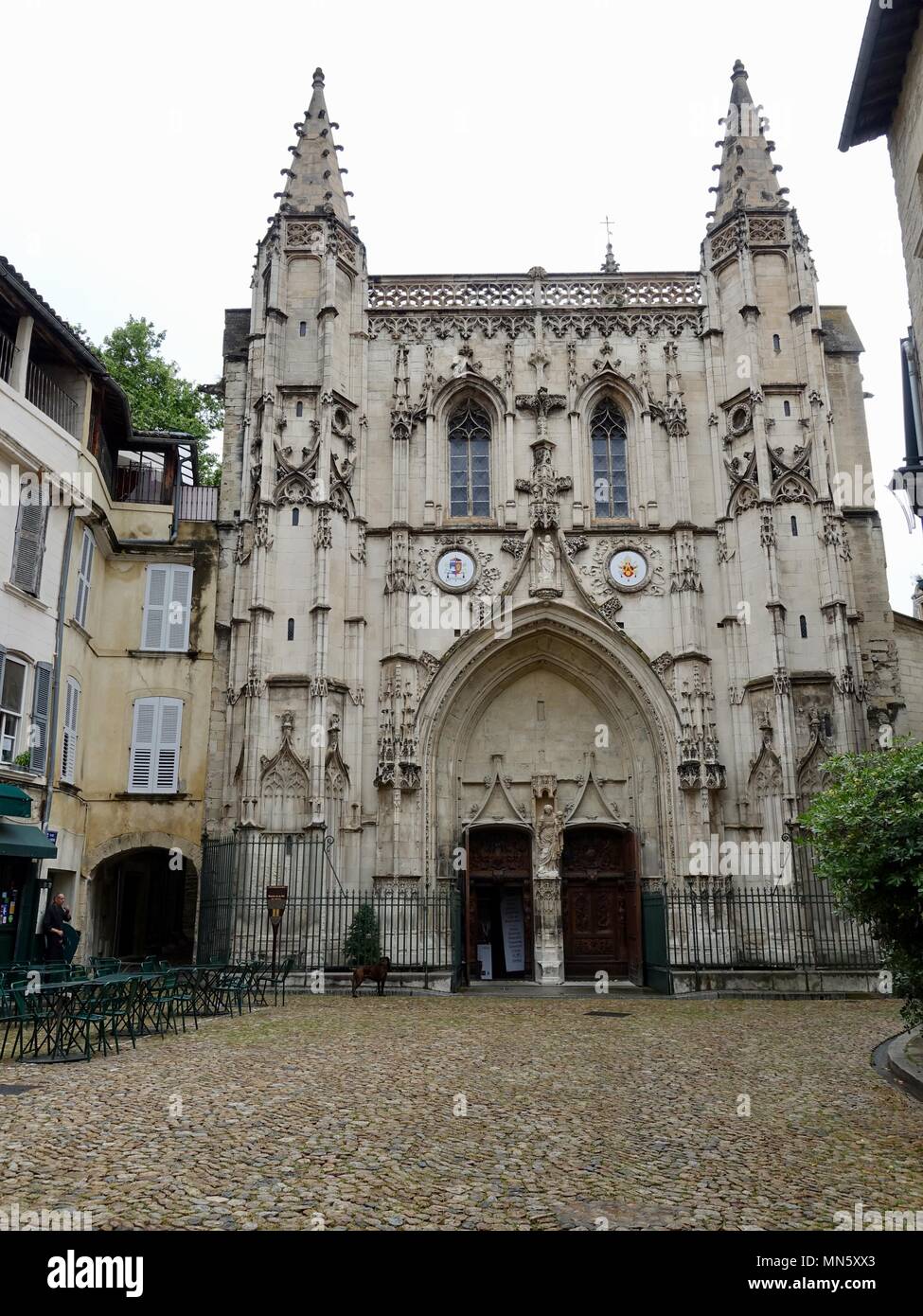 La facciata anteriore della Basilica Saint-Pierre Avignon, Francia e quasi un vuoto cortile in ciottoli. Foto Stock