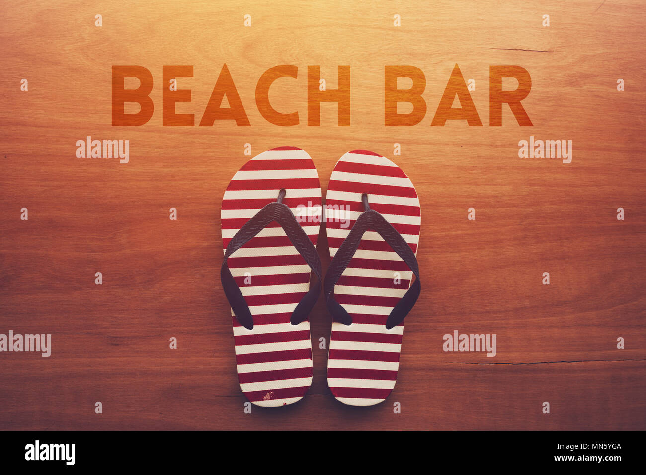 Bar sulla spiaggia e sandali infradito su sfondo di legno, vacanze estate Concetto di vacanza Foto Stock