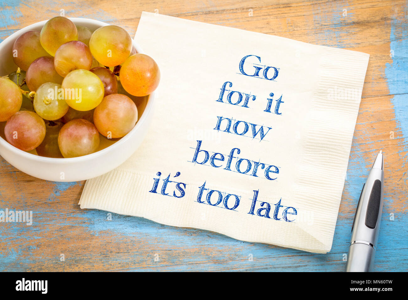 Andateci prima che sia troppo tardi - scrittura su un tovagliolo con uve fresche Foto Stock