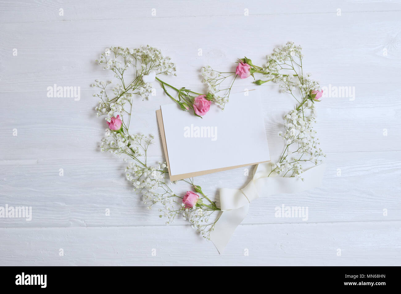 Mock up composizione cuore di fiori bianchi in stile rustico Foto Stock