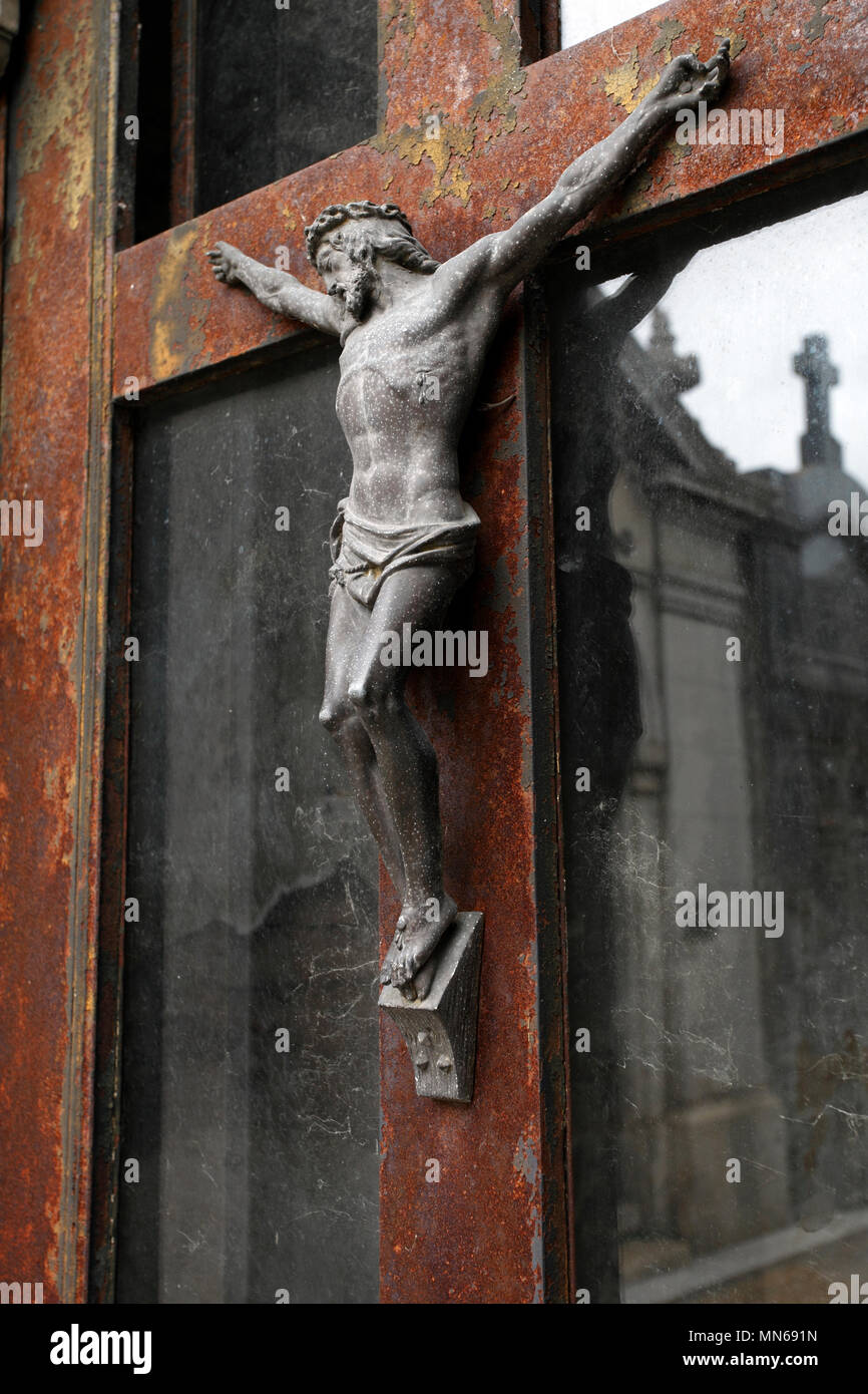 Statua su una porta, di Gesù inchiodato alla croce. Foto Stock