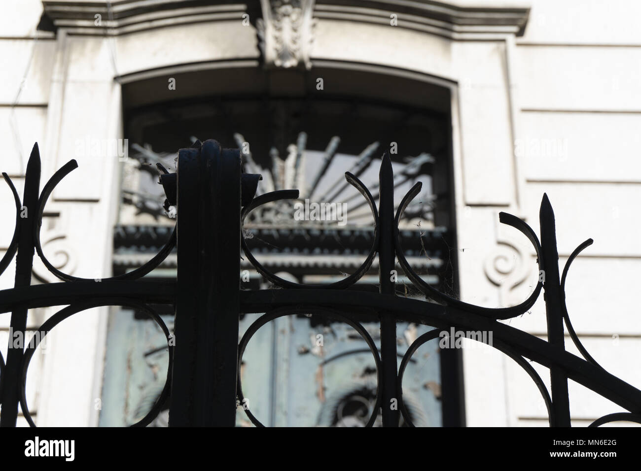 Guarda dall'esterno dietro il cancello di ferro antico e scolpiti in stile gotico Foto Stock