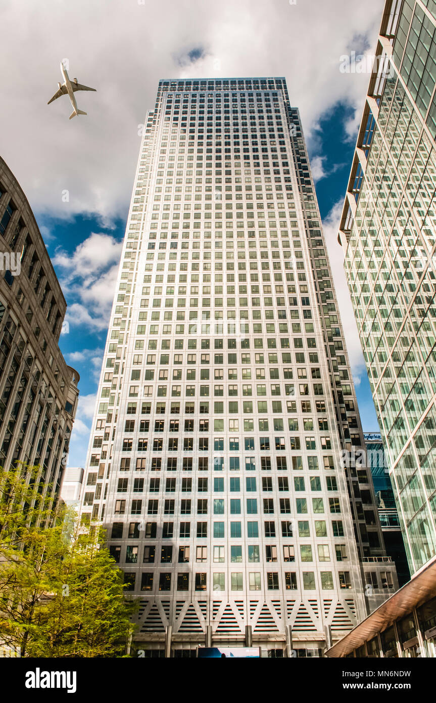 Un aereo vola basso su One Canada Square, Canary Wharf, Londra. Foto Stock