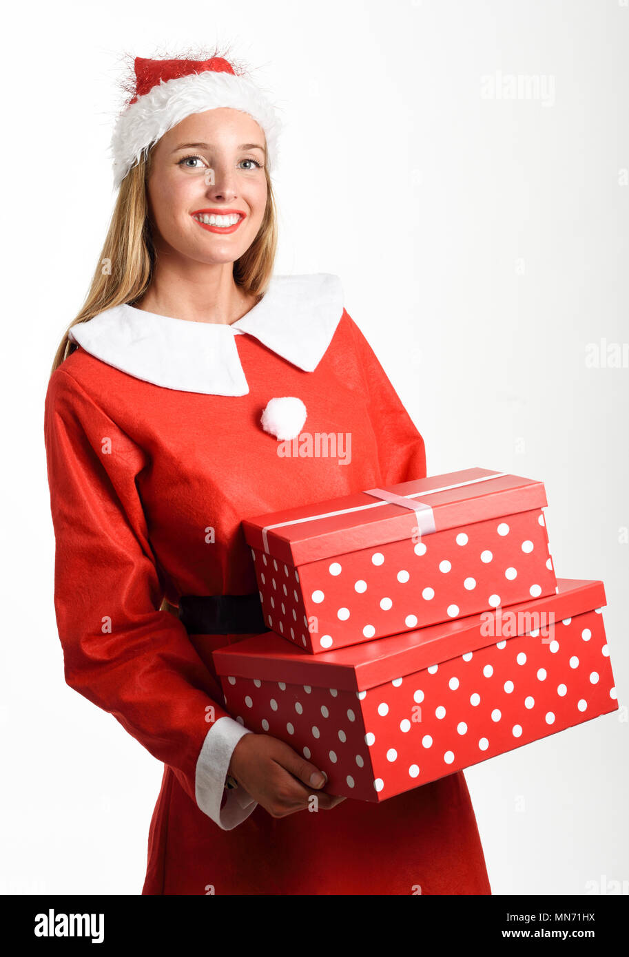 Donna bionda in Santa Claus vestiti sorridente con confezioni regalo nelle sue mani. Giovani femmine con gli occhi blu, isolato su bianco Foto Stock