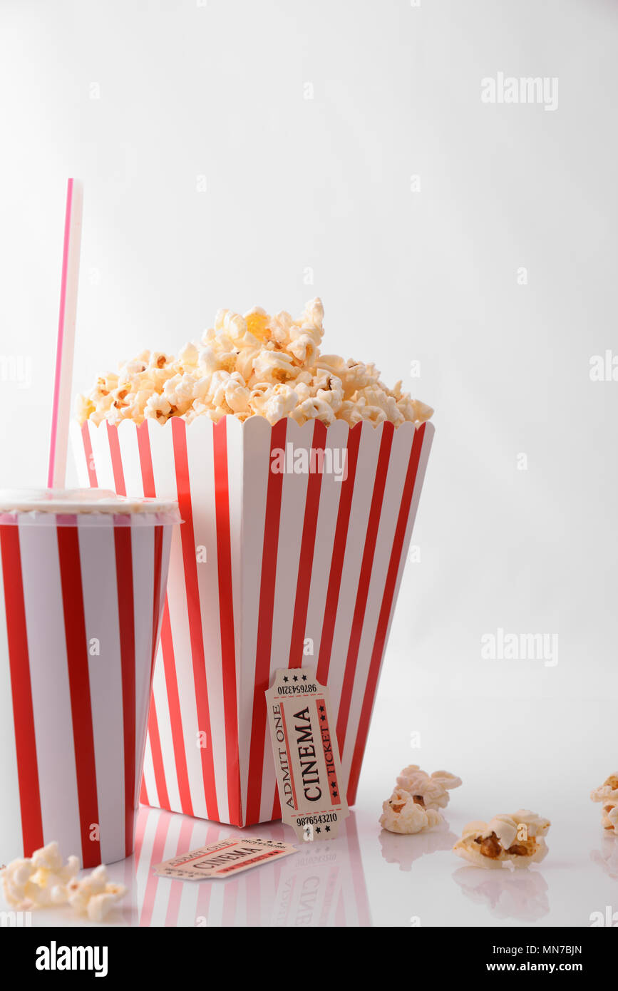 Momenti di Cinema concetto con ristoro, popcorn e biglietti per il cinema su sfondo bianco. Composizione verticale. Vista frontale. Foto Stock