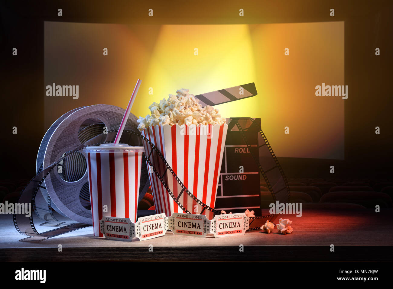 Le attrezzature e gli elementi del cinema sul tavolo di legno e lo sfondo del cinema. Concetto di guardare film. Composizione orizzontale. Vista frontale. Foto Stock