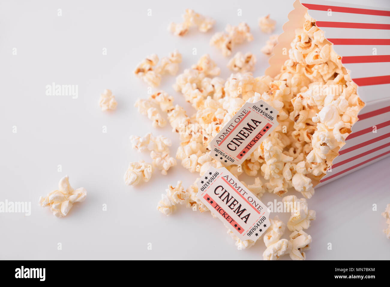 Momenti di Cinema concetto con popcorn e biglietti per il cinema su sfondo bianco. Composizione orizzontale. Vista dall'alto. Foto Stock