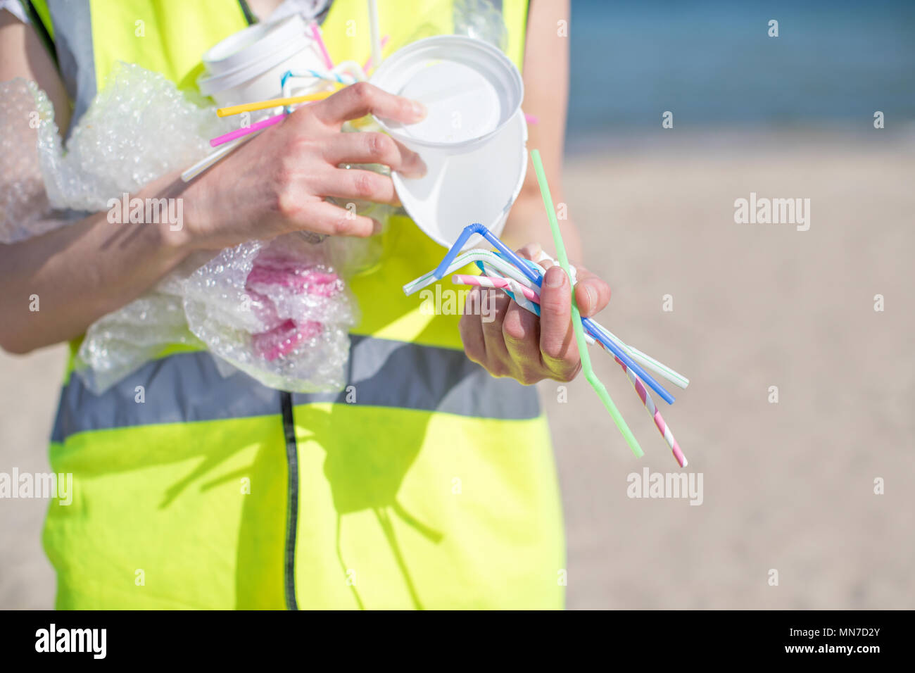 Close Up di persona la raccolta dei rifiuti di plastica da spiaggia inquinati Foto Stock