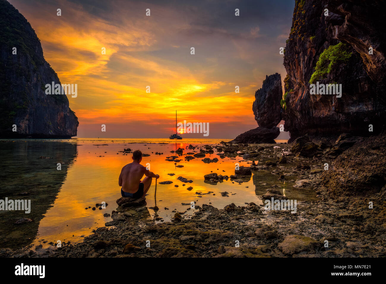 Ragazzo giovane gode di tramonto spettacolare al Maya Beach in Thailandia Foto Stock